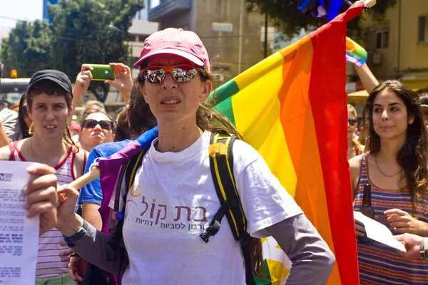 Ung kvinna med regnbågsflaggan på pride paraden ta — Stockfoto