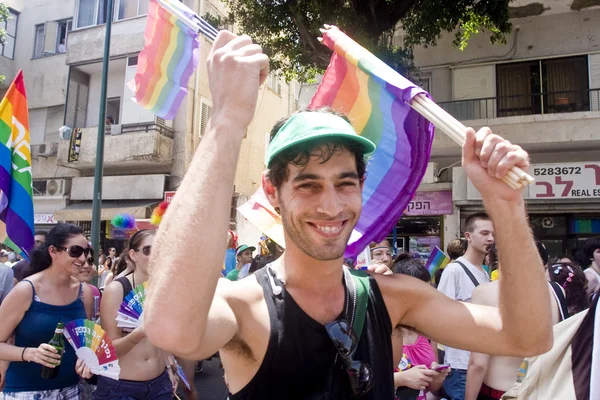 Joven sonriente con bandera de arco iris en Pride Parade TA — Foto de Stock