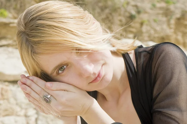 Blonde girl listening to a shell — Stock Photo, Image