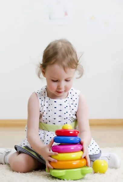 Klein meisje spelen in een piramide-speelgoed — Stockfoto