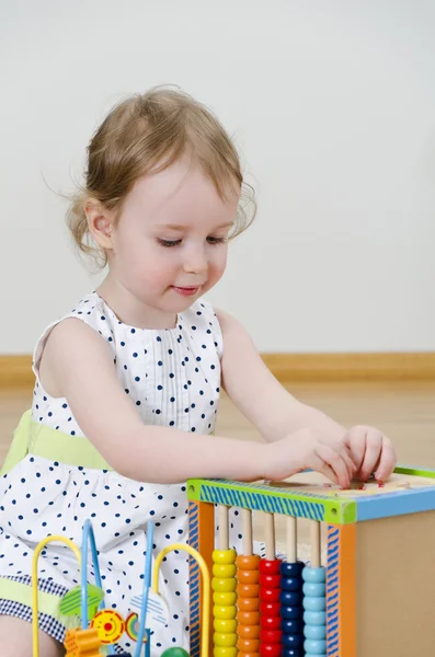 Gelişmekte olan bir oyuncak oynarken küçük kız — Stok fotoğraf