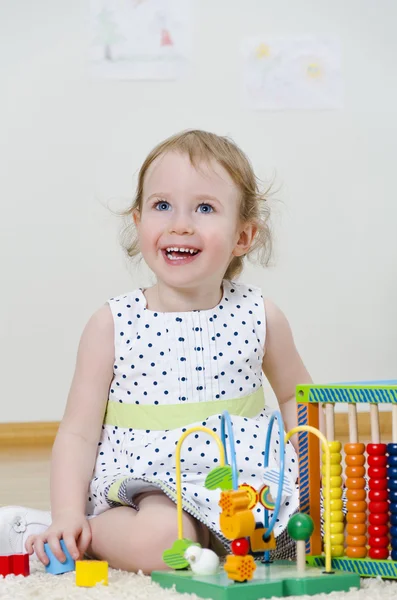 Gelişmekte olan bir oyuncak oynarken küçük kız — Stok fotoğraf