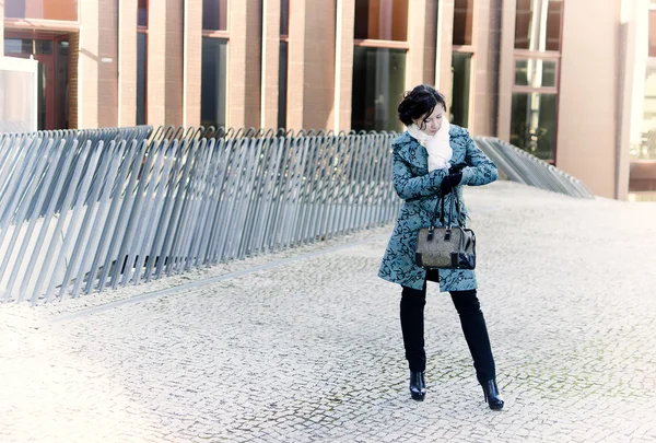 Una chica con una bolsa esperando la reunión. Mira el reloj. — Foto de Stock