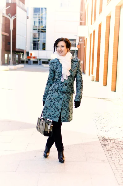 Bella ragazza sorridente in cappotto in piedi all'aperto — Foto Stock