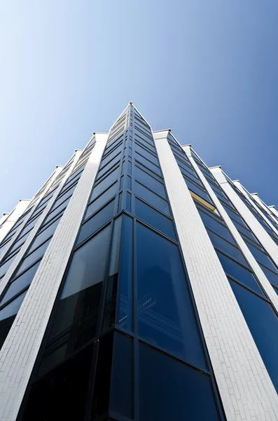 Kantoorgebouw onder blauwe wolkenloze hemel — Stockfoto