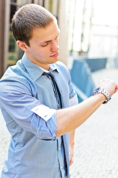 Επιτυχημένος άνδρας, κοιτάζοντας το ρολόι του. πέρα από το αστικό υπόβαθρο. — Φωτογραφία Αρχείου