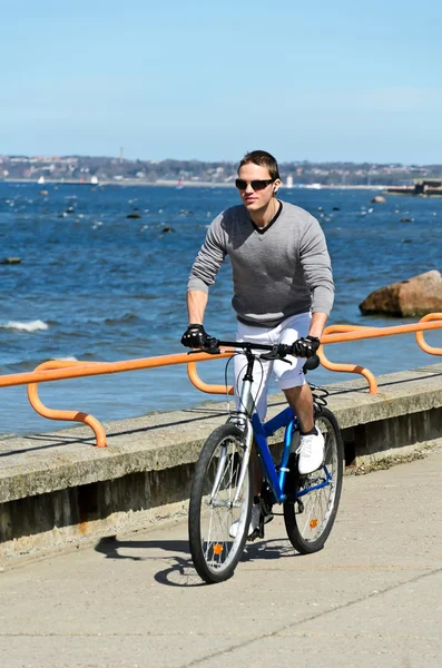 Deniz kenarında bir bisiklet sürme yakışıklı erkek portresi — Stok fotoğraf