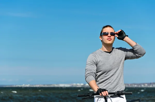 Ritratto di bel maschio con bicicletta al mare — Foto Stock