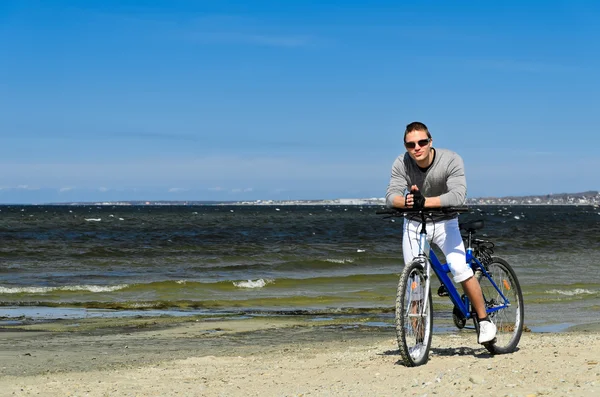 Retrato de hombre guapo con bicicleta junto al mar — Foto de Stock