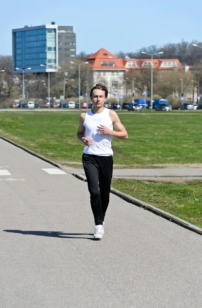 Спортивний молодий чоловік біжить містом — стокове фото