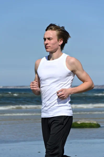 Lekkoatletycznego mężczyzna młody działa na plaży — Zdjęcie stockowe