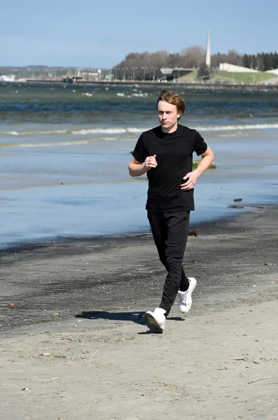 Athletic young male running on the beach — Stock Photo, Image