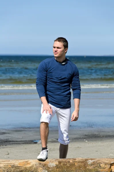 Jovem homem de pé na praia — Fotografia de Stock