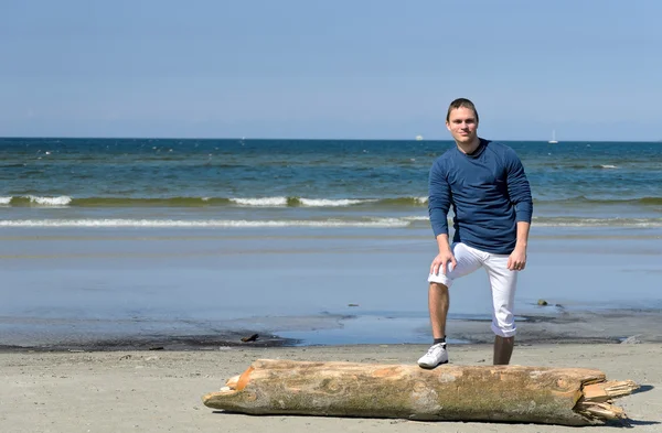Молодой мужчина стоит на пляже — стоковое фото