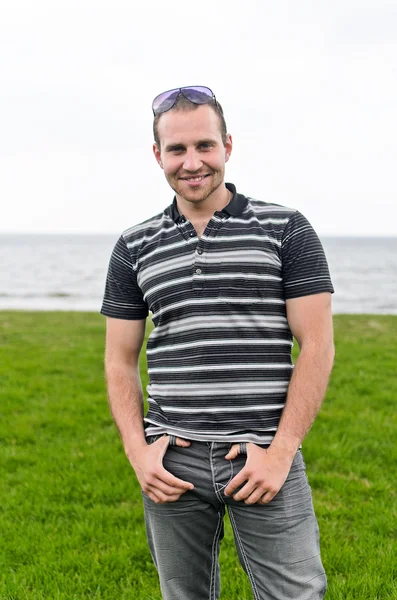 Handsome smiling man near the seaside. — Stock Photo, Image