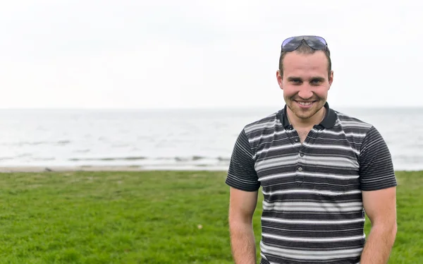 Handsome smiling man near the seaside. — Stock Photo, Image