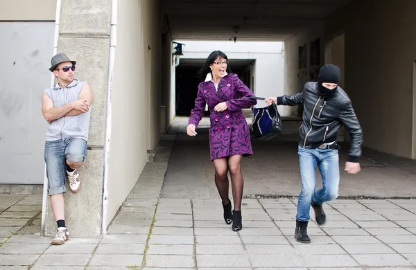 Robo diurno en la calle. Ladrón roba una bolsa . — Foto de Stock