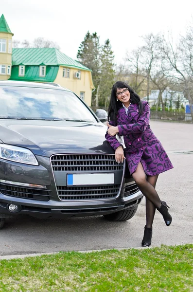 Bella donna posa vicino auto costosa — Foto Stock