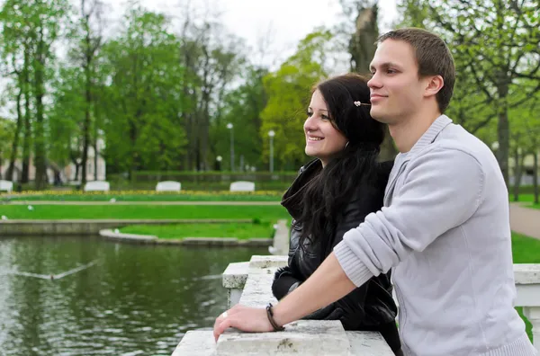 Nettes Paar blickt auf einen Teich im Park — Stockfoto