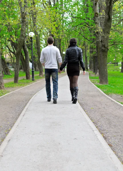 Paar, das die Straße im Park entlang geht. von hinten — Stockfoto