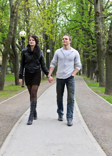 Para spacerująca w dół drogi w parku. — Zdjęcie stockowe