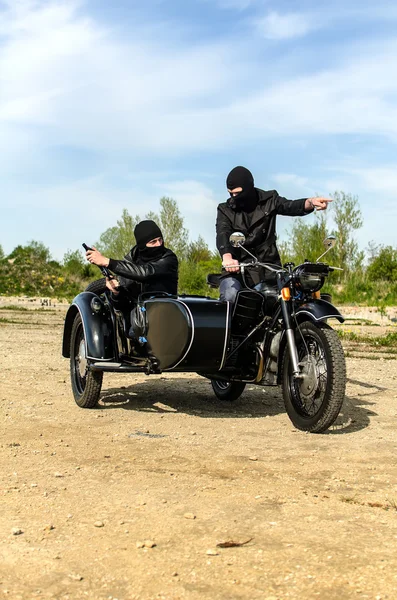 Two armed men riding a motorcycle with a sidecar — Stock Photo, Image