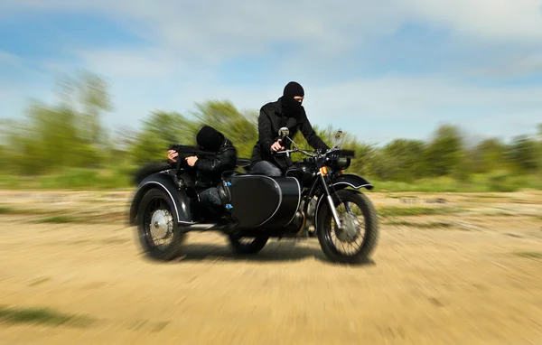 Two armed men riding a motorcycle with a sidecar. Motion blur. — Stock Photo, Image