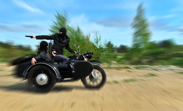 Zwei bewaffnete Männer auf einem Motorrad mit einem Beiwagen. Bewegungsunschärfe. — Stockfoto