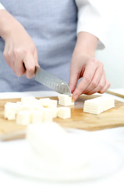 Las manos de mujer cortando queso feta — Foto de Stock