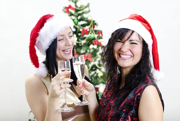 Navidad: dos chicas en sombrero rojo se divierten —  Fotos de Stock