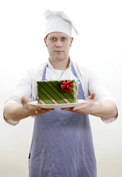 Chefkoch mit einem Geschenk auf dem Teller — Stockfoto