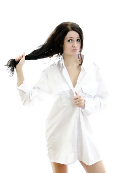 Smyslná brunetka v Pánské košili dotýká její vlasy. Izolované na wh — Stock fotografie