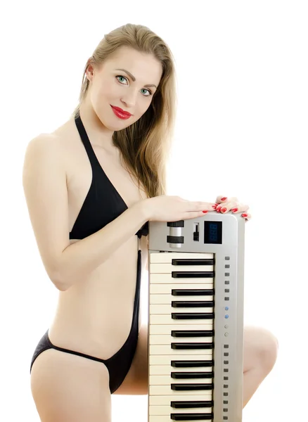 Kadın siyah mayo piyano klavye ile poz. beyaz izole. — Stok fotoğraf