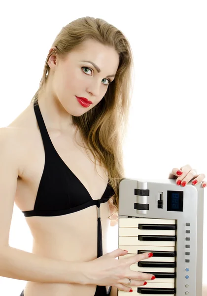 Kvinnan i svart baddräkt poserar med piano keyboard. isolerad på vit. — Stockfoto