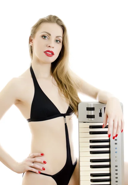 Kadın siyah mayo piyano klavye ile poz. beyaz izole. — Stok fotoğraf