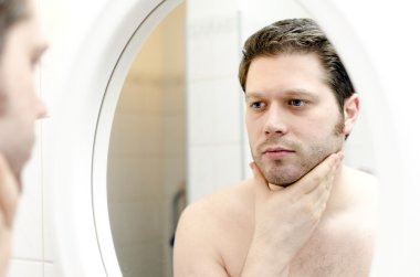 Man looks at his beard and thought about shaving clipart