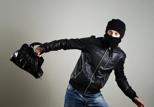 Portrait of running male burglar with a handbag. — Stockfoto