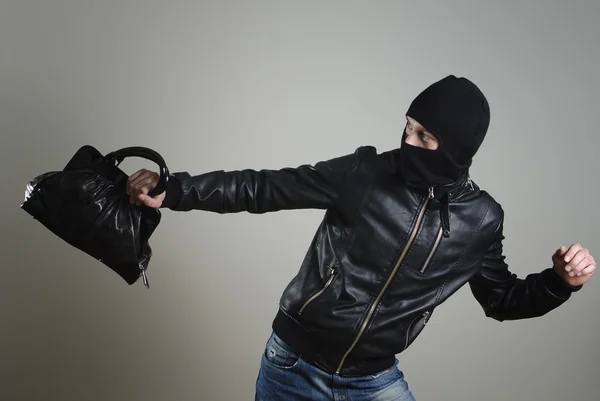 Portrait of running male burglar with a handbag. — Stock Photo, Image