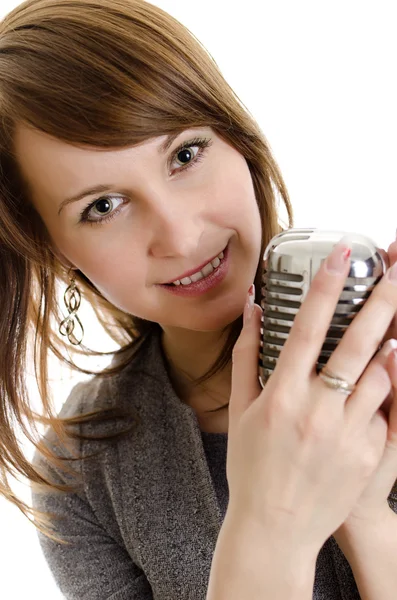 Mujer joven sosteniendo un micrófono retro. Aislado sobre blanco . — Foto de Stock