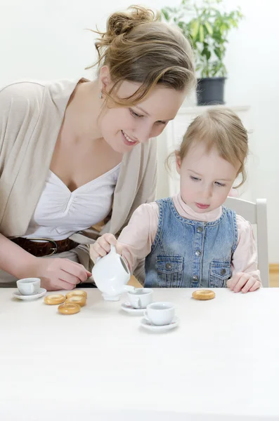 妈妈和女儿喝茶与百吉饼 — 图库照片