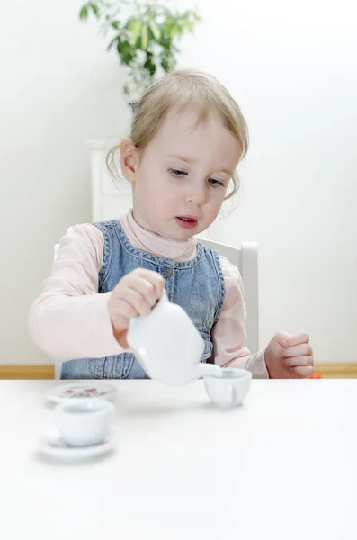Χαριτωμένο μικρό κορίτσι που πίνει τσάι στο σπίτι. — Φωτογραφία Αρχείου