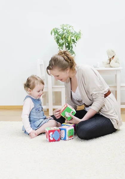 Mother and daughter playing in the children's cubes — Stock Photo, Image