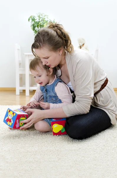 Mother and daughter playing in the children's cubes — Stock Photo, Image