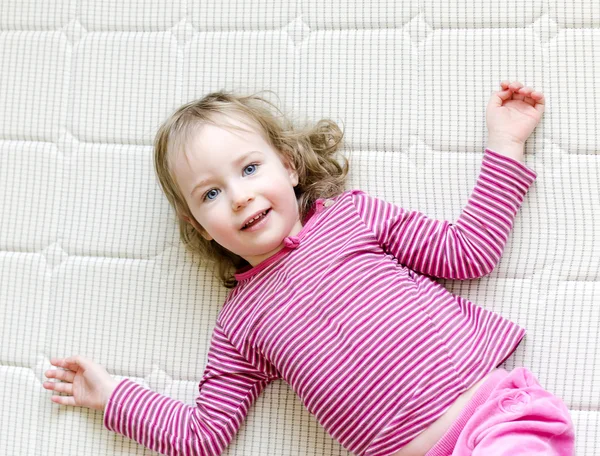 Linda niña acostada en un colchón —  Fotos de Stock