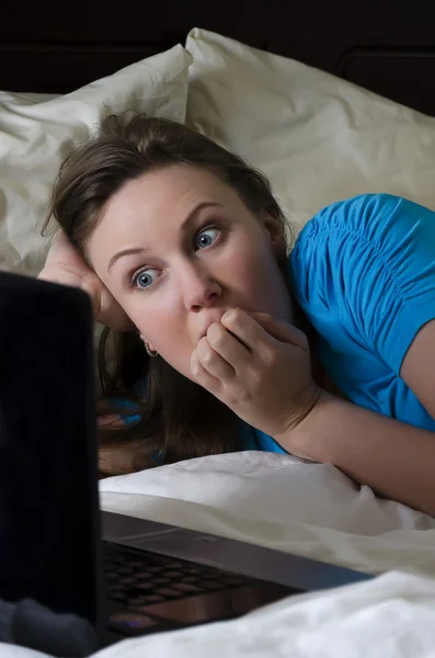 Young woman scared while watching movie in dark room — Stock Photo, Image