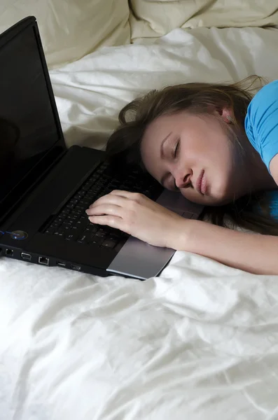 年轻的女孩学生累了和便携式计算机上就睡着了 — 图库照片