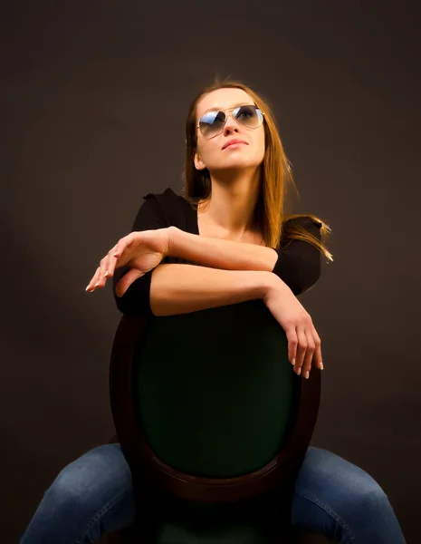 Sexy meisje, zittend op een stoel — Stockfoto
