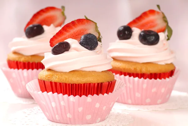 Vanilj cupcakes med stawberry glasyr och jordgubbar och bl — Stockfoto