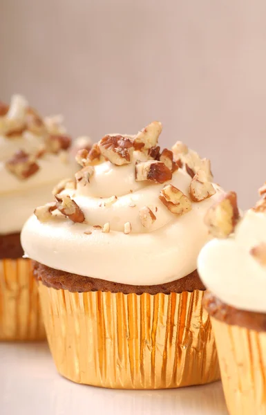 Delicious carrot cake cupcake with cream cheese frosting and nut — Stockfoto