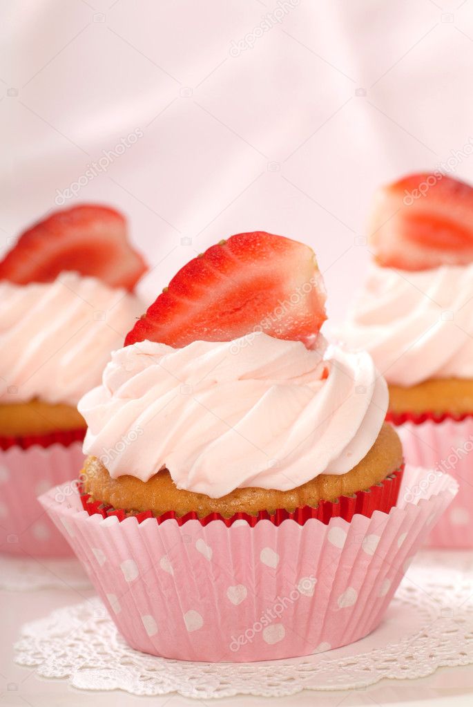 Vanilla cupcakes with stawberry frosting and strawberries